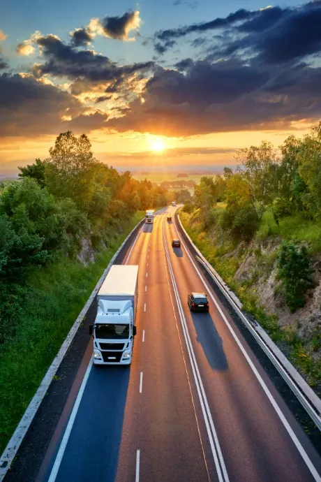 Freight truck driving on a highway at sunset